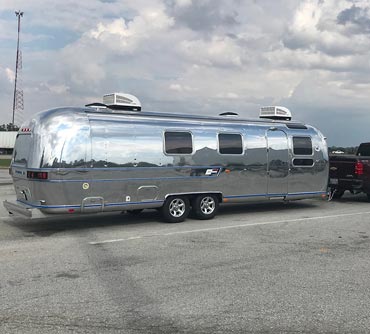 Truck pulling Polished Airstream International on road